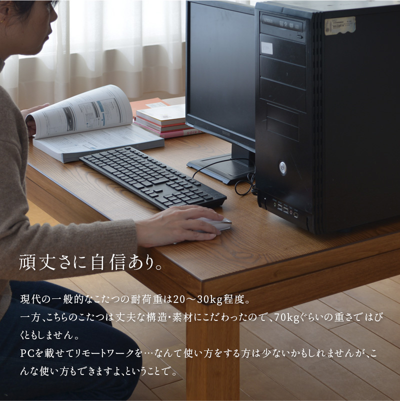 こたつ上にPCを置いて作業する女性